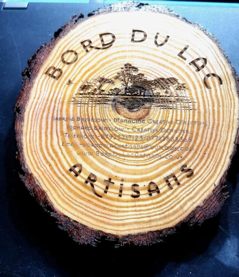 Bord Du Lac Artisan logo engraved on a pine waney edge stand with feet.