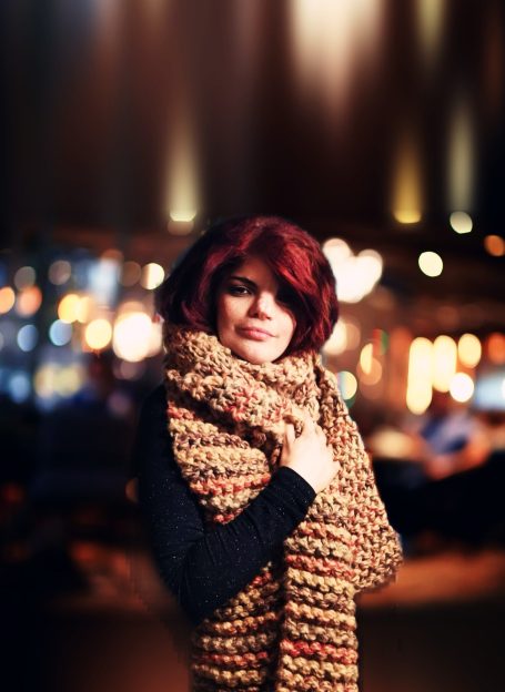 Bord Du Lac founder models a hand knitted scarf, jammy colour, from the Adventures in Wool Collection