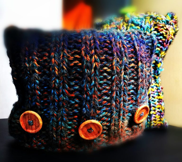 Unique hand-knitted textile with big wooden buttons from the Countryside Collection in the Adventures in Wool at Bord Du Lac Artisans.